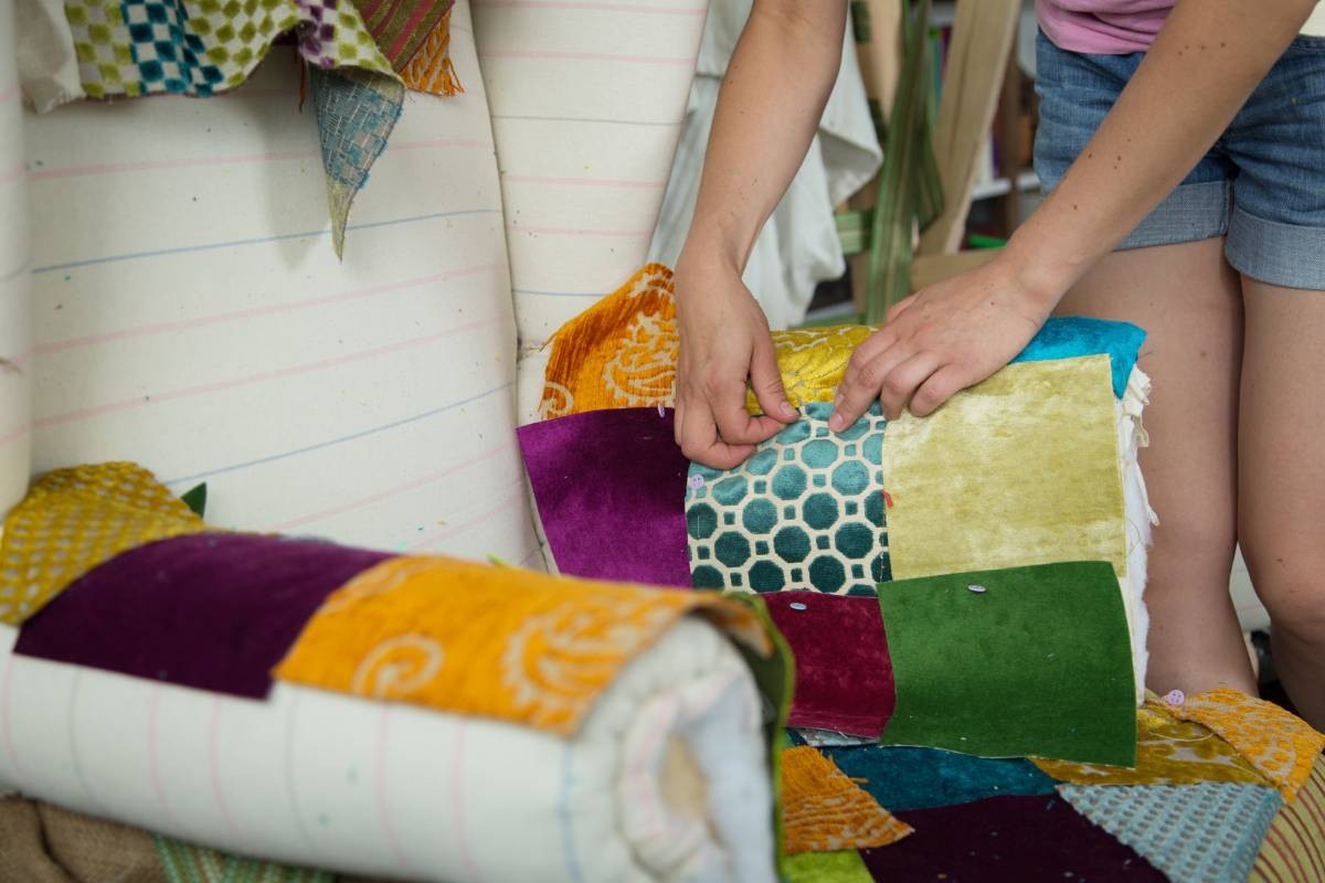 Someone applying new upholstery to their chair at Porro's Custom Interiors near Worcester, MA